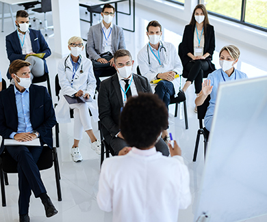 A group of masked medical staff attend a training session