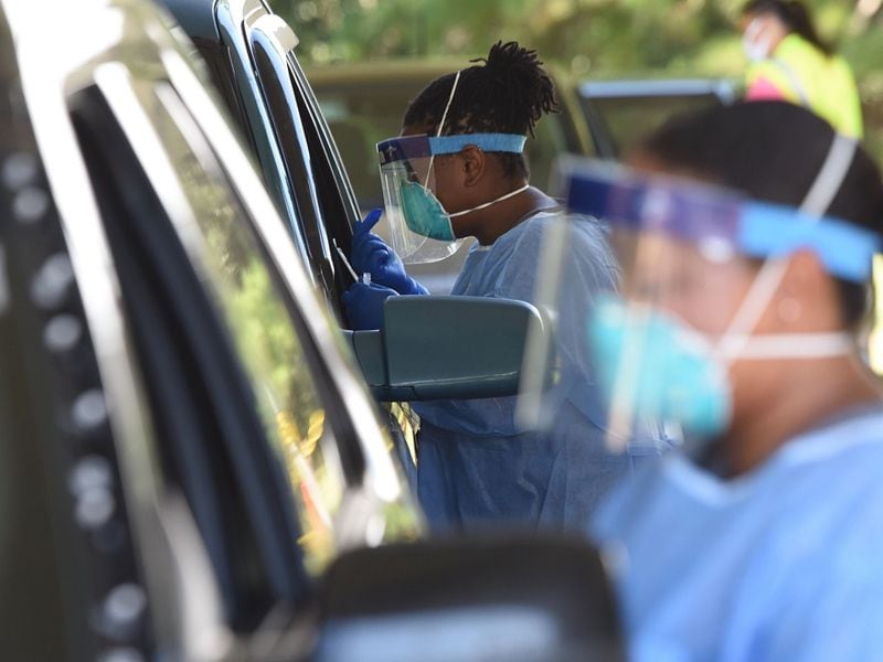 Registered nurses Jesslyn Lewis (center) and Sasha Stewart (Right) conduct COVID-19 tests outside the Glynn County Health Department in Brunswick on Tuesday, July 14, 2020. 
RYON HORNE / RHORNE@AJC.COM