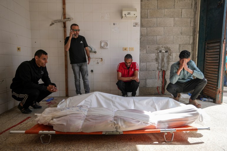 Palestinians react next to the bodies of their relatives who were killed in an Israeli airstrike in Gaza Stirp, at the Al Aqsa hospital in Deir al Balah, Gaza, Saturday