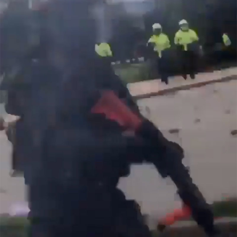 Colombian security forces throwing tear gas and beating protesters.