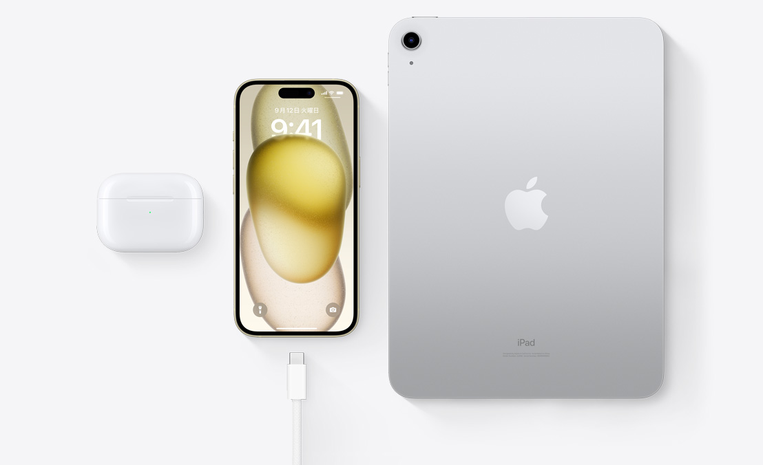 AirPods Pro、iPhone 15、iPadとUSB-Cコネクタを上から見た図。3つすべてのデバイスを同じUSB-Cケーブルで充電できることを示している。