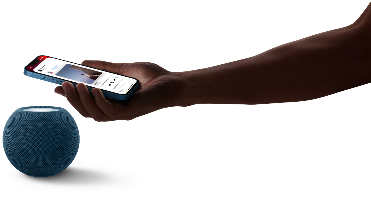 Blå HomePod mini och en hand som håller en iPhone över HomePod mini. Musik spelas på iPhone-skärmen.