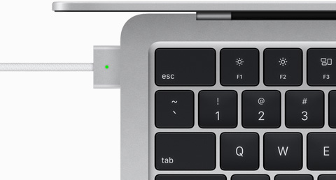 Billede ovenfra af et MagSafe-kabel, som er tilsluttet en MacBook Air i farven sølv