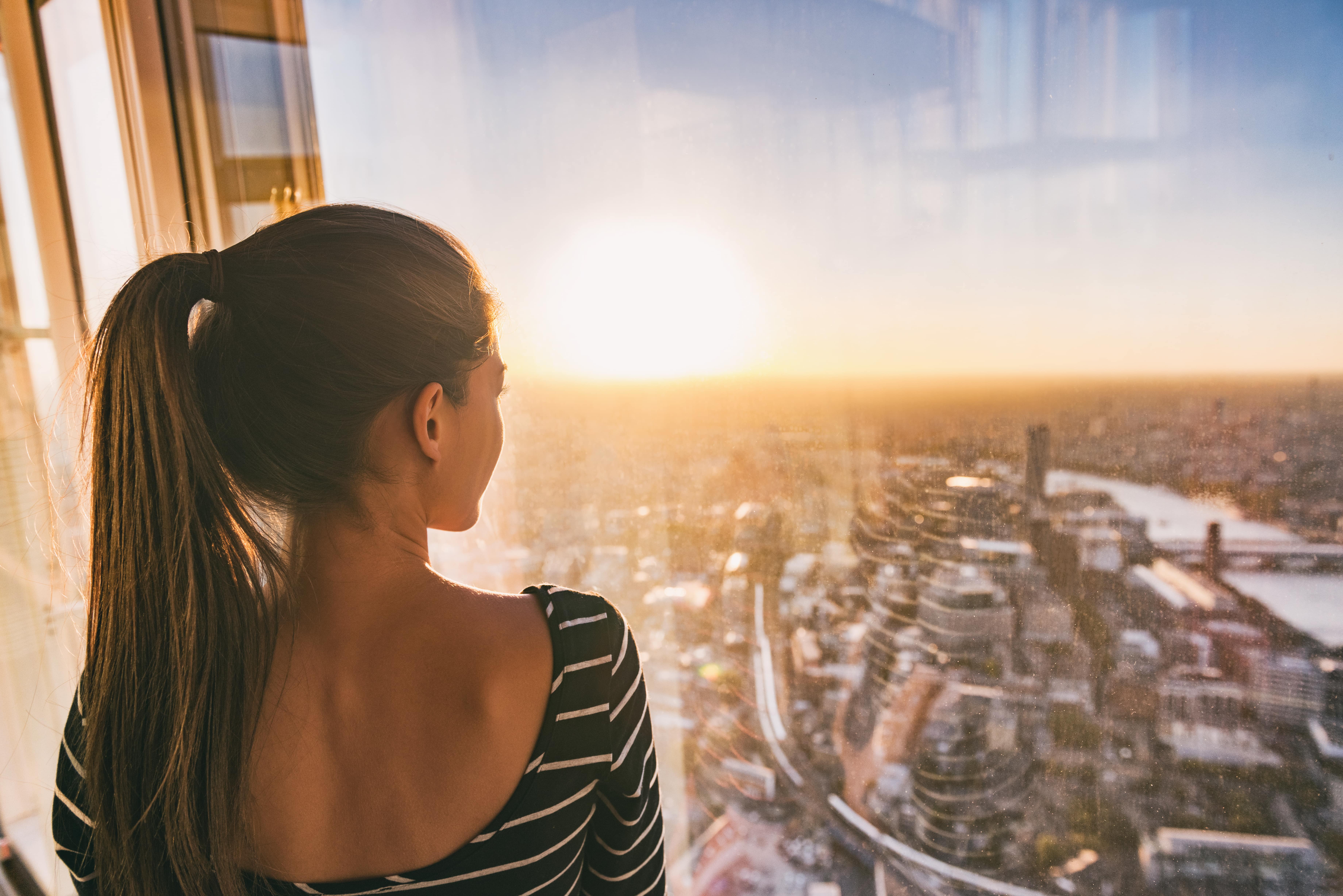Woman looking at the sunset view of London's skyline from The Shard