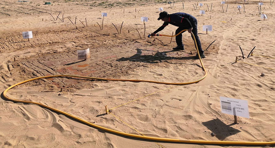 A man spraying clay onto the ground before planting any plants