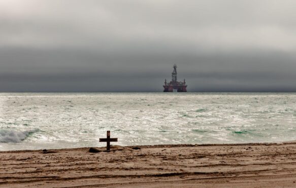 An oil rig looms amid threatening skies over the Atlantic Ocean off the coast of Namibia.