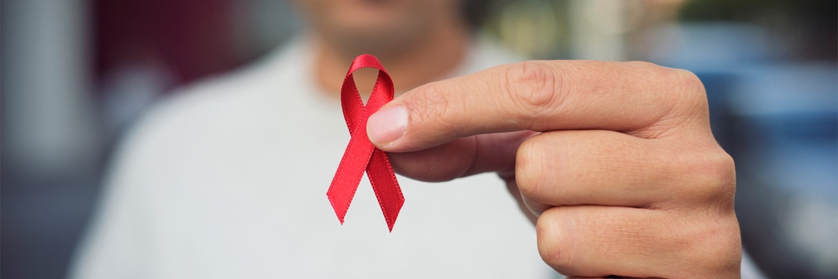 Un hombre con un lazo rojo por la lucha contra el SIDA