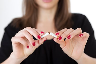 Woman breaking a cigarette in half