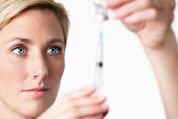 nurse filling up a syringe