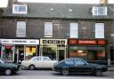 A photograph from the 1980s depicting three shops on Bridge Street, Musselburgh. They are H. Maudling (wines and spirits), Robb's (hairdresser) and W. Harrower (bookmaker). All images courtesy of East Lothian Archives & Museums