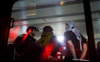 The NYPD load arrested protesters from Columbia University onto a bus (Julius Motal/AP)