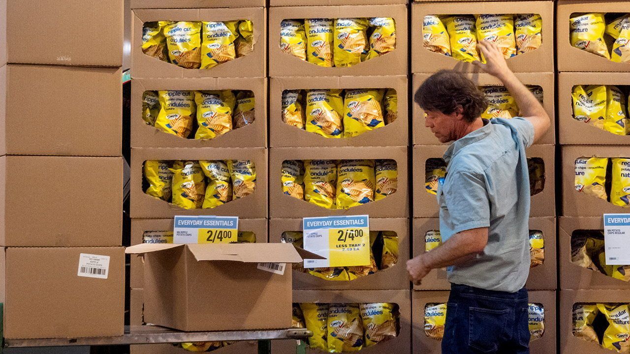 An employee restocking potato chips at a grocery store in Toronto