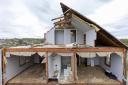 A partially torn off roof is seen on a damaged home in Omaha, Nebraska (Chris Machian/Omaha World-Herald via AP)