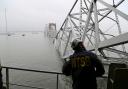 In this image released by the National Transportation and Safety Board, a NTSB investigator is seen on the cargo vessel Dali, which struck and collapsed the Francis Scott Key Bridge (Peter Knudson/NTSB/AP)