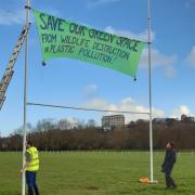 Exeter's Extinction Rebellion group installs a banner as part of its protest over approved plans for a 3G playing pitch on Flowerpot Playing Fields.