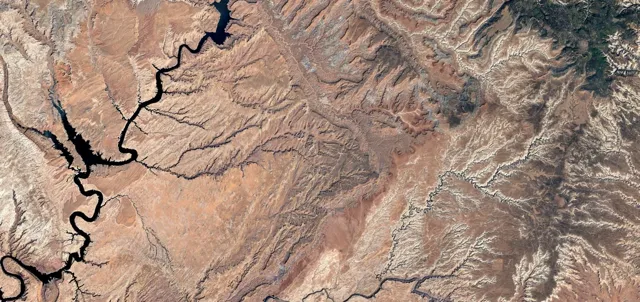 Aerial view of a plot of land showing brown earth and waterways
