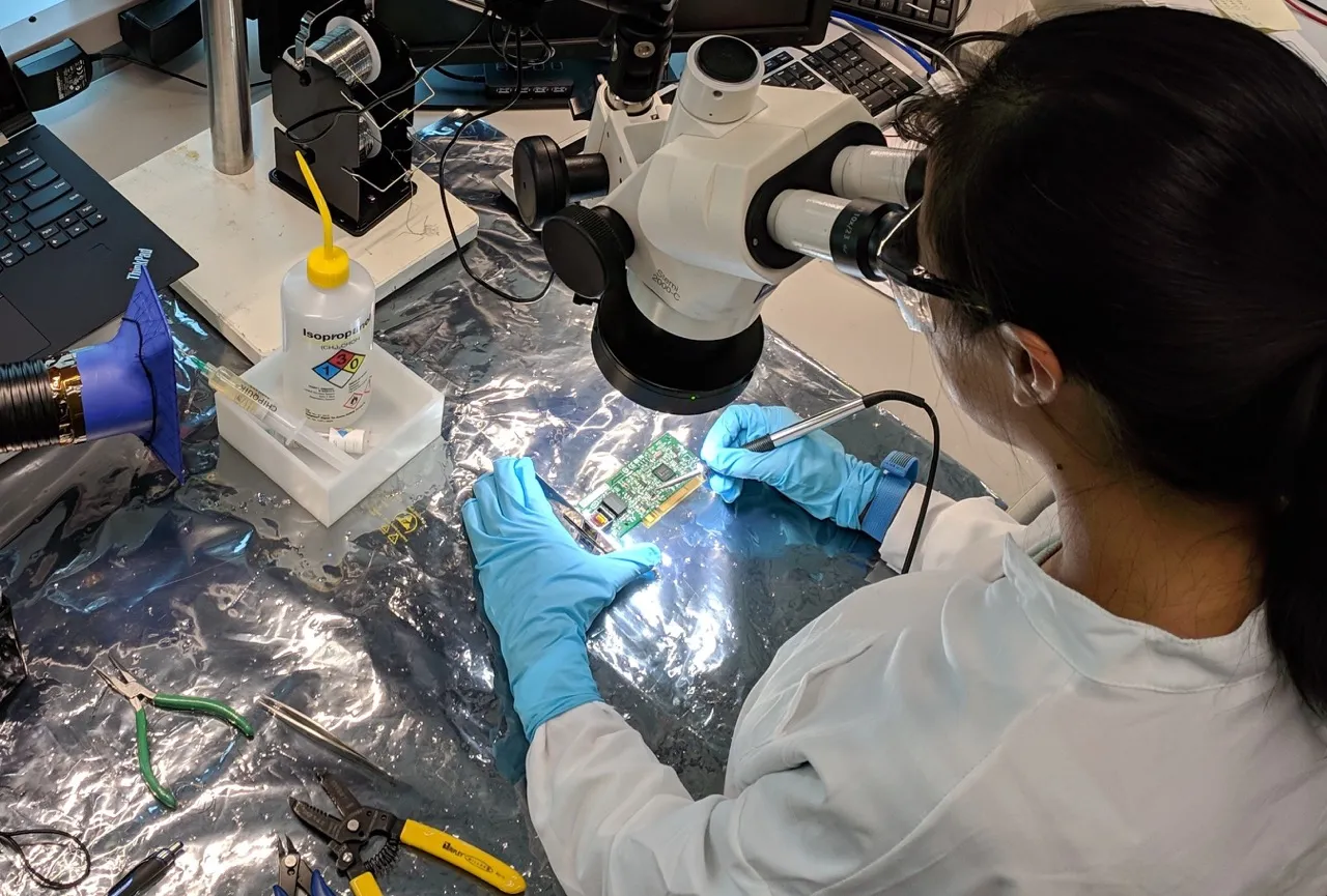 Image of supplier working on a device under a microscope