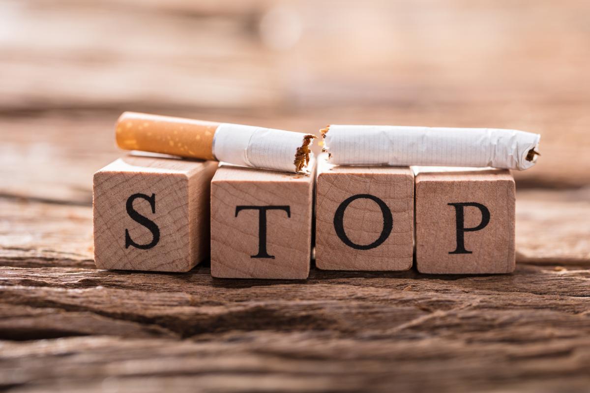 Image of a broken cigarette on top of wooden blocks spelling the word stop