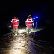 Firefighters rescuing a car from floodwater this morning