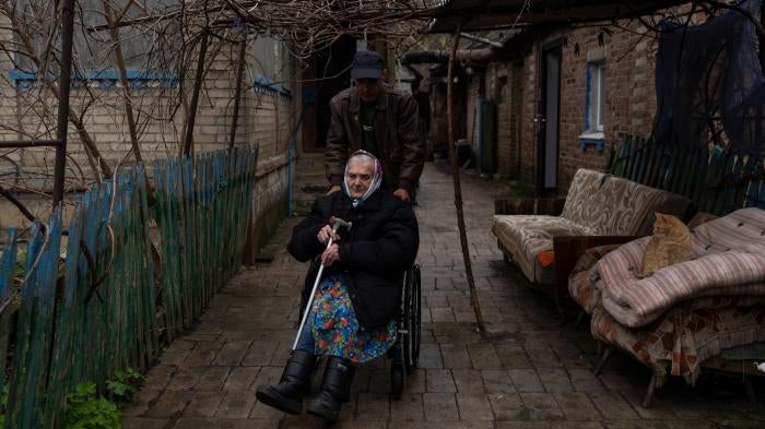 An older woman using a wheelchair is evacuated from a hospice