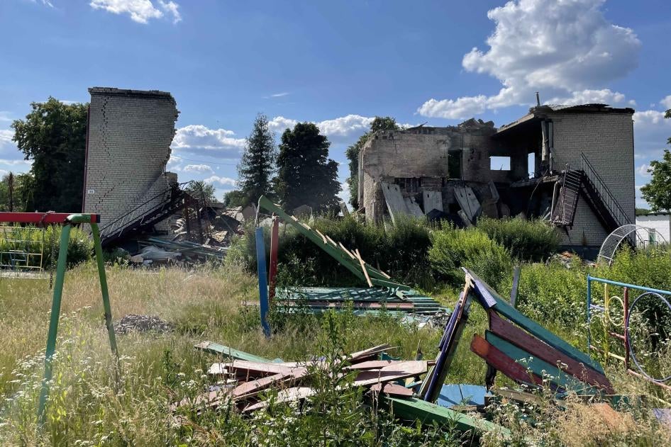 A damaged playground outside of a destroyed school building