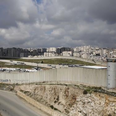 A concrete wall separates a city and a highway