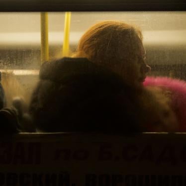 A woman and two children sitting inside a bus