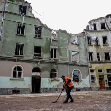 A communal worker sweeps outside an apartment building in Lviv, Ukraine, on July 7, 2023, a day after it was seriously damaged by a Russian missile strike. 