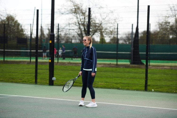 Player laughing on court during a Free Park Tennis session