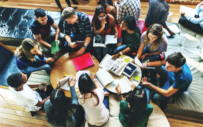 A group of students collaborate around a table.