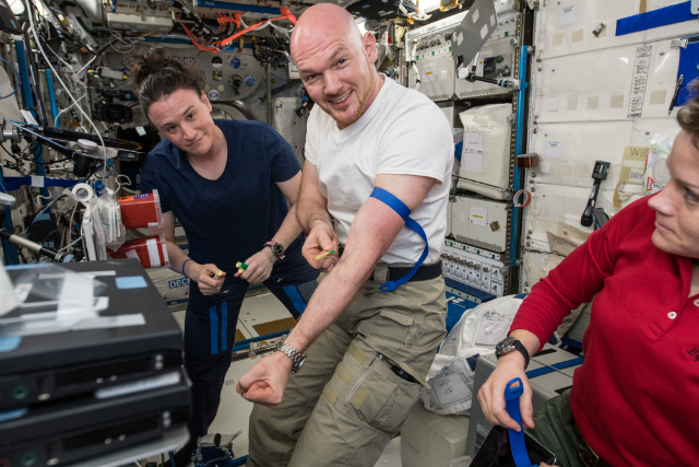 image of astronauts Alexander Gerst and Serena Auñón-Chancellor collecting blood samples from themselves inside ISS