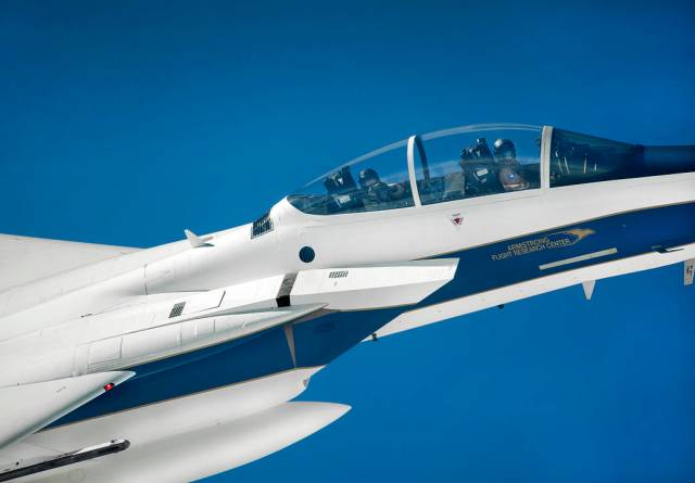 Closeup of F-15D chase plane showing pilot in cockpit against blue sky