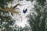 A white blanket of snow contrasts with the dark-blue water, emphasizing the lake’s heart-like shape when viewed from above.