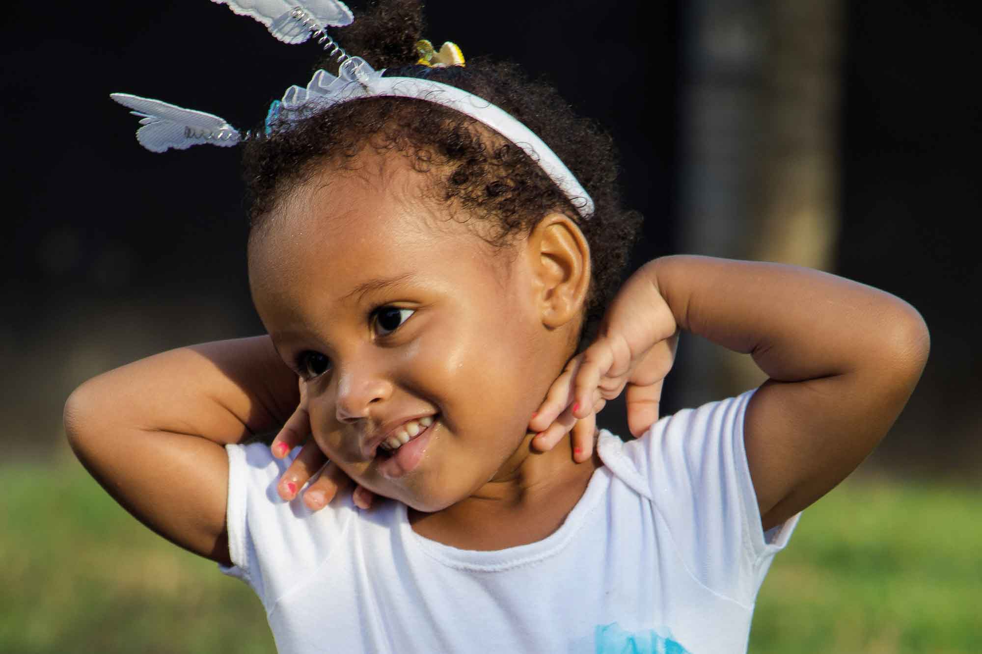 a happy child wearing a headband with butterflies