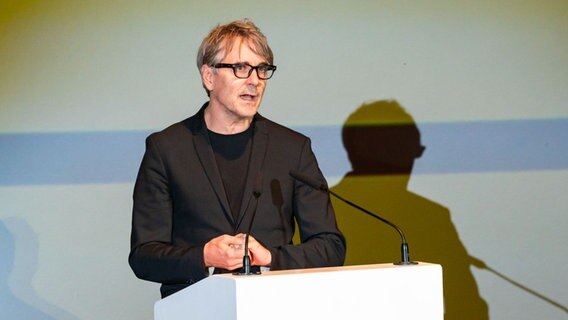 Ein Mann mit grauen Haaren steht vor einem Rednerpult und trägt eine schwarze Brille. © picture alliance/dpa Foto: Jonas Walzberg