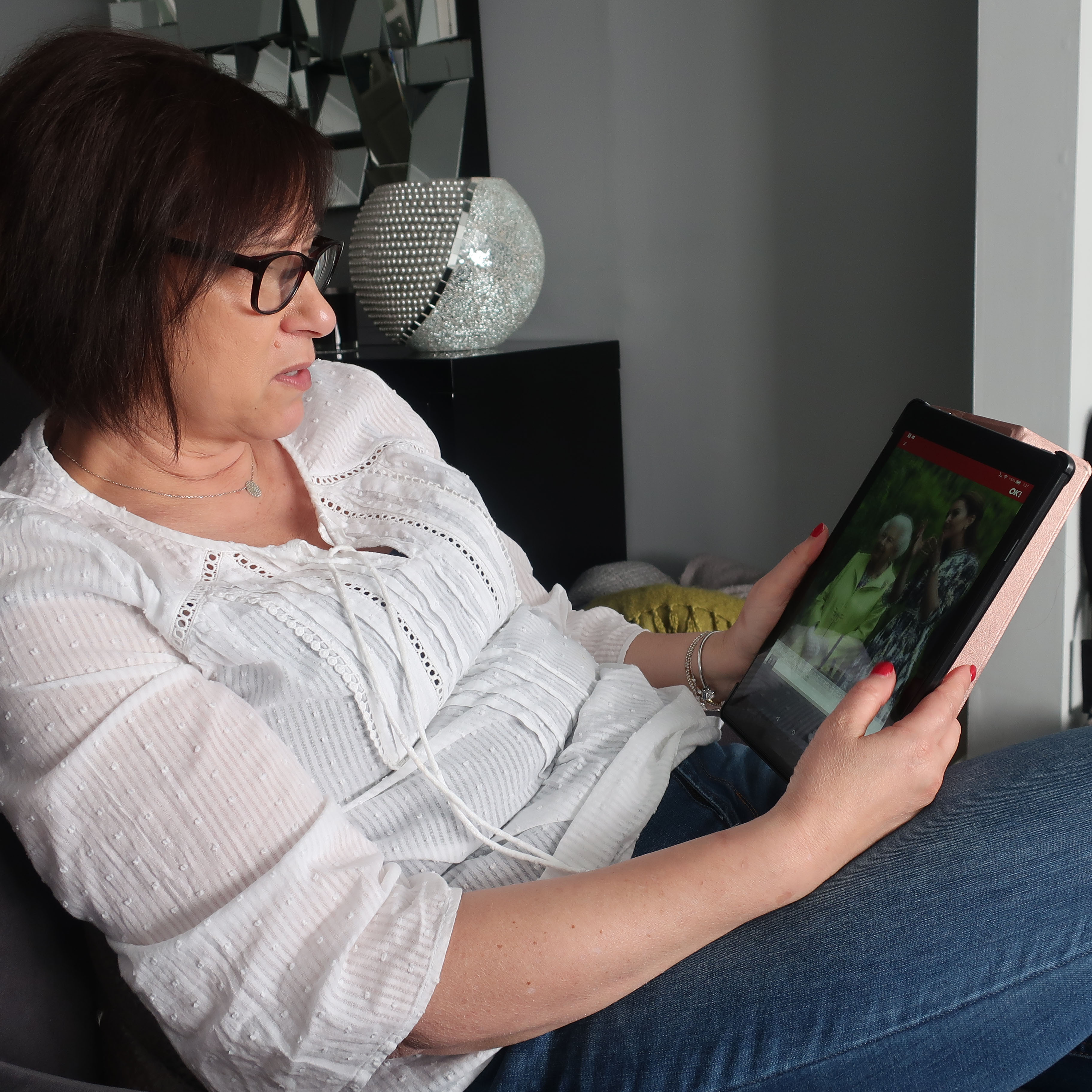 A woman reading BBC News on a tablet device.