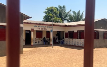 People sit in the shade at a school that is closed due to an extreme heat wave alert in Juba, South Sudan