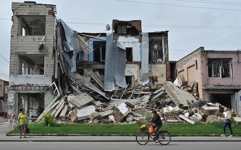 Local residents walk past a destroyed store in the city of Okhtyrka in the Sumy region. As towns and villages across Ukraine's eastern countryside fell to the swift Russian invasion, Okhtyrka, a city of 48,000 on the Vorskla River, resisted occupation