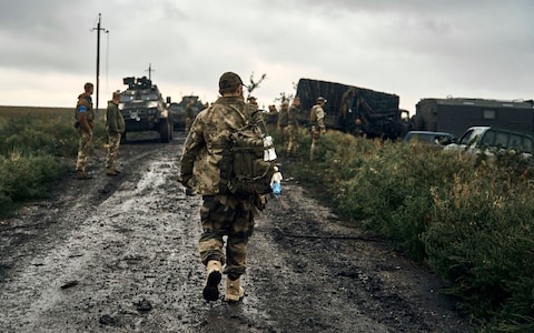 Ukrainian soldiers stand on the road in the freed territory of the Kharkiv region, Ukraine, Monday, Sept. 12, 2022. 