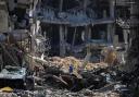 A man inspects damage and removes items from their home following Israeli airstrikes in Khan Yunis, Gaza