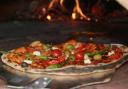 A pizza being removed from an oven