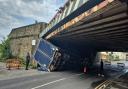 The truck on its side under the bridge