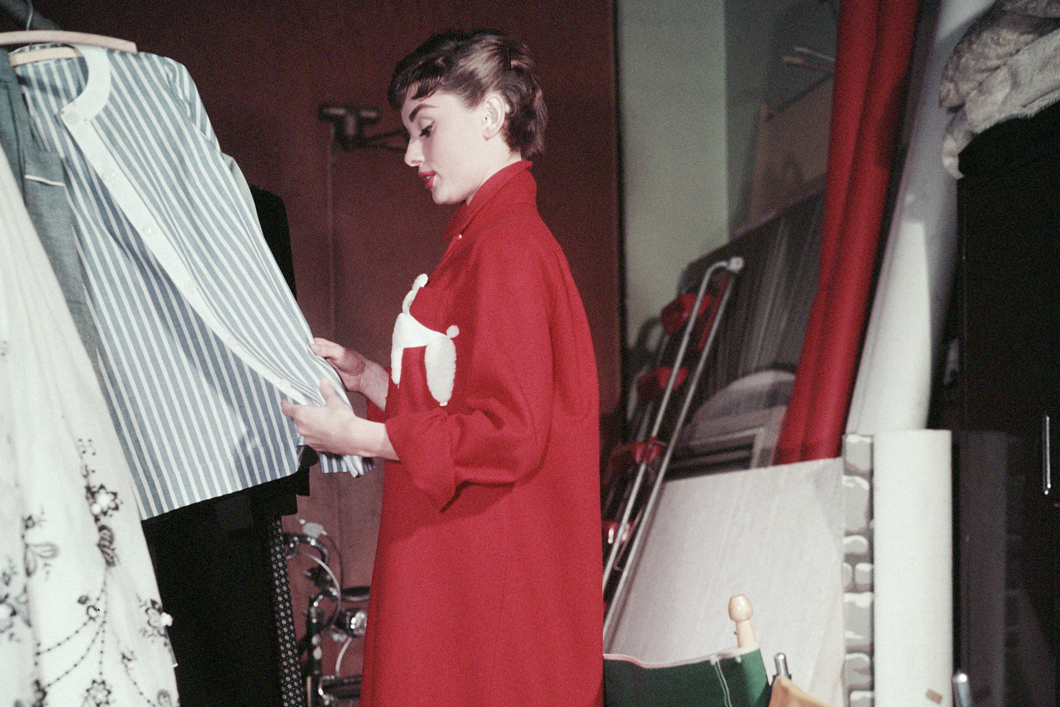 Audrey Hepburn browsing her wardrobe, c 1955