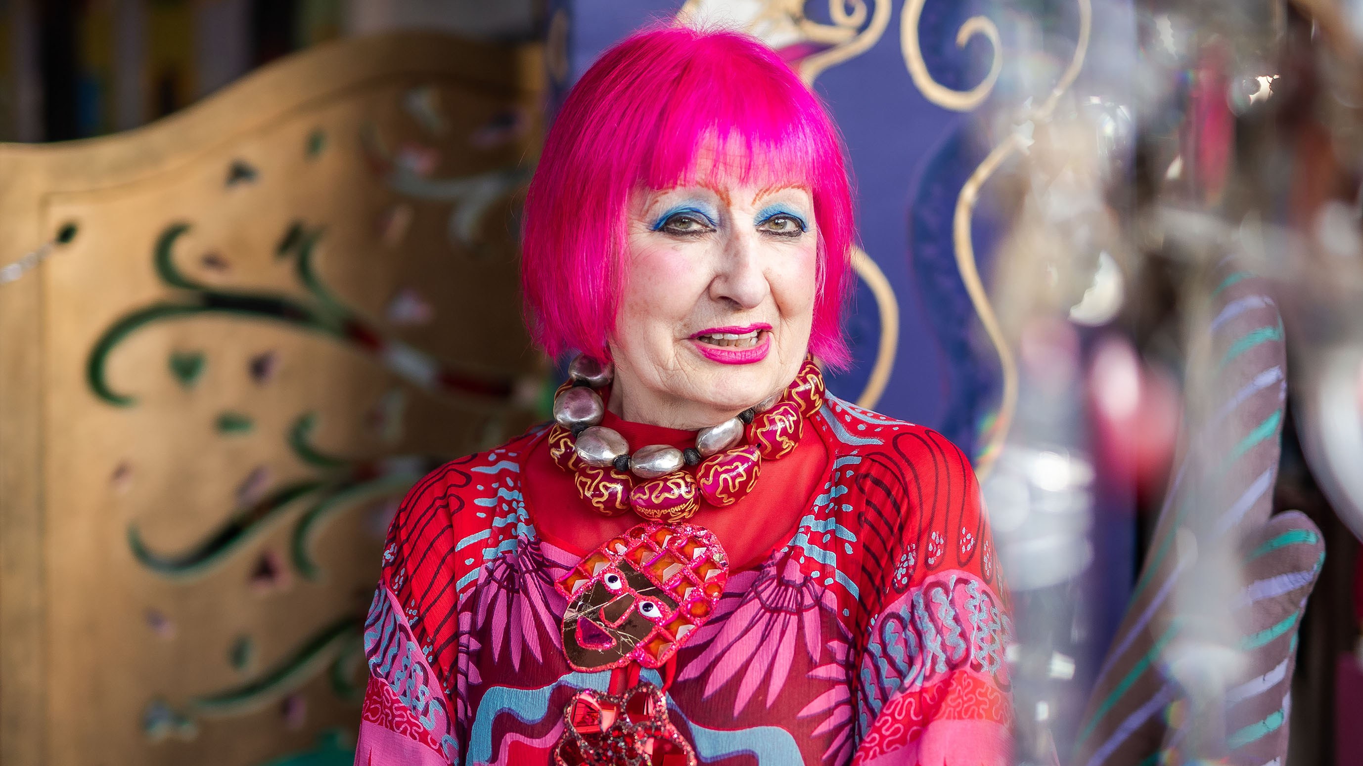 Zandra Rhodes in her home studio in London. “My hair is pink; I’m not accepting that it’s grey. I dye it every month”