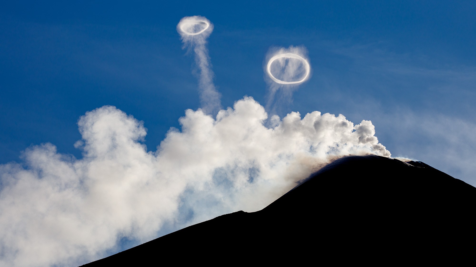 Vortex rings, seen rising from Mount Etna, actually help prevent a violent volcanic eruption