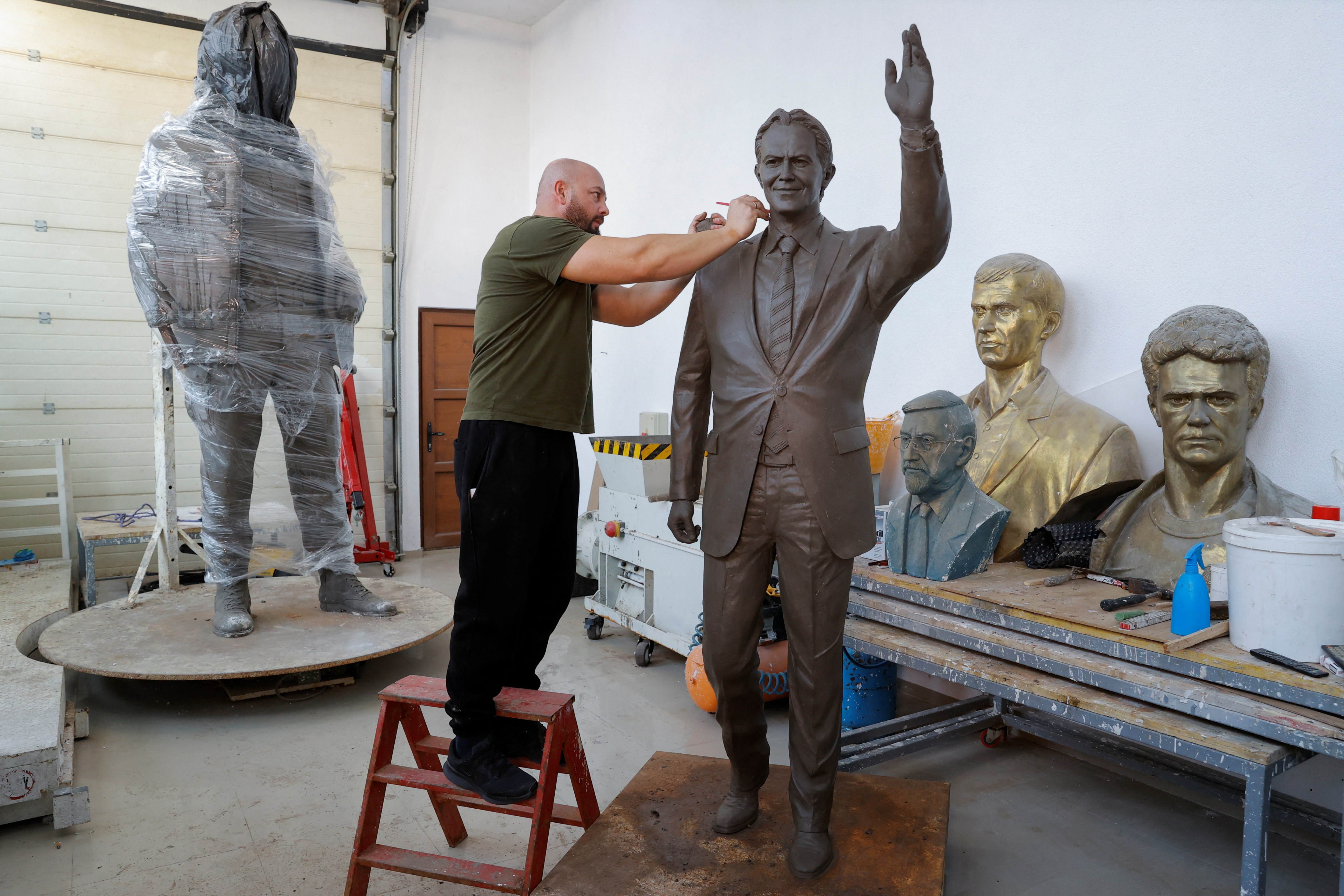 Agon Qosa, a Kosovo Albanian sculptor, puts the finishing touches to a statue of Sir Tony Blair to be placed on a boulevard in Ferizaj, eastern Kosovo. Many ethnic Albanians in the country idolise the former British prime minister for his backing of a NATO bombing campaign against Serbia in 1999, which forced it to withdraw from Kosovo