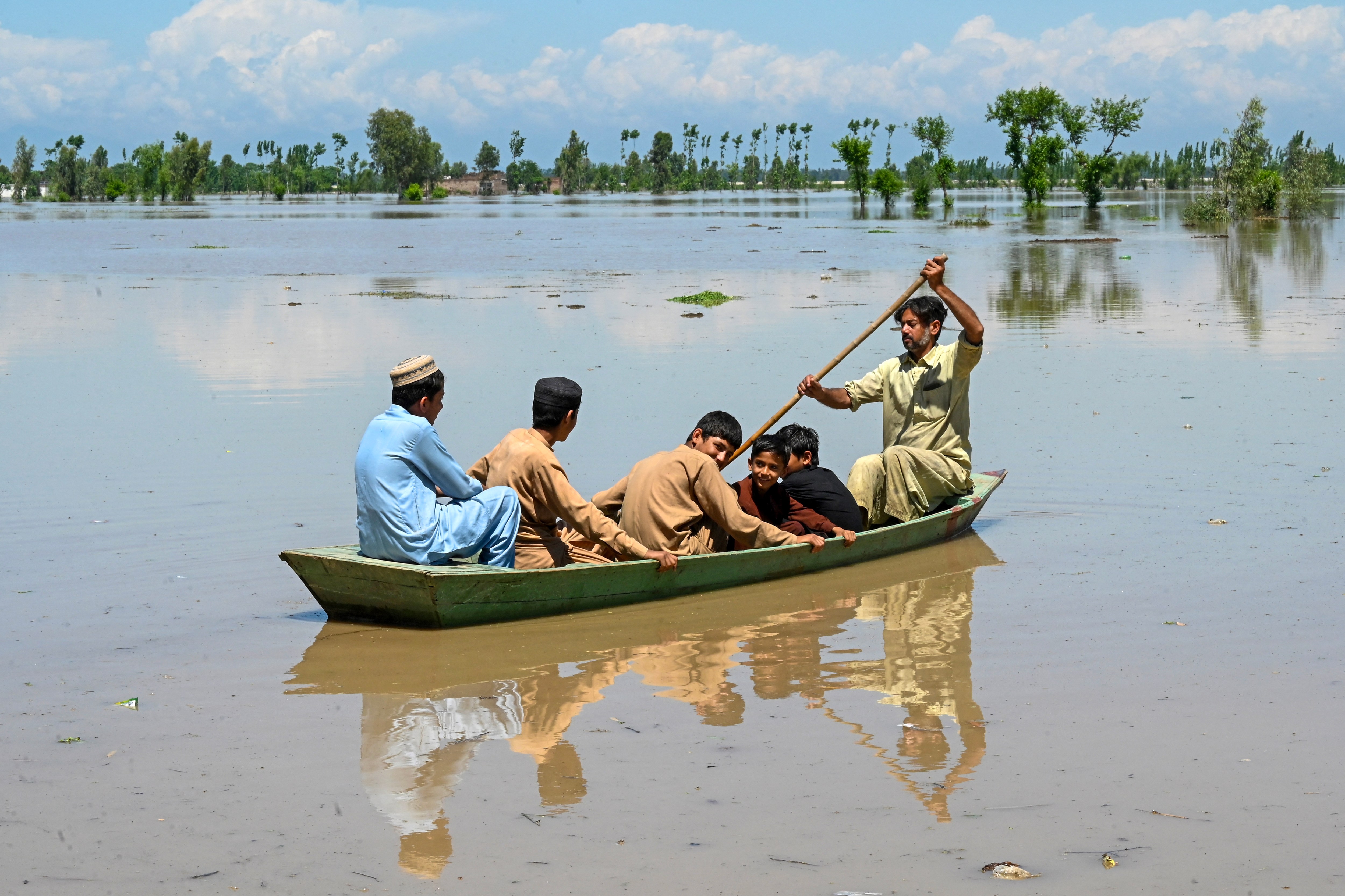 Villagers cross a flooded area in the northern province of Khyber-Pakhtunkhwa in Pakistan. Heavy rain and lightning across the country have killed at least 50 people in the past three days, with authorities declaring a state of emergency in some regions