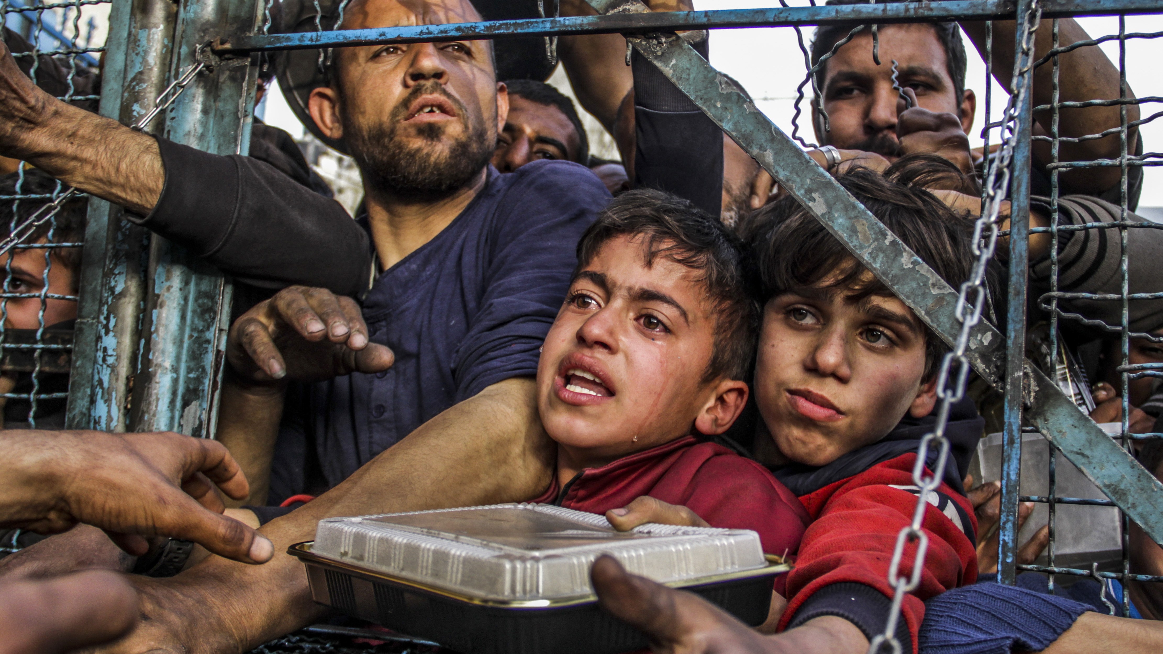 Palestinians wait to receive food in Jabalia, Gaza this week