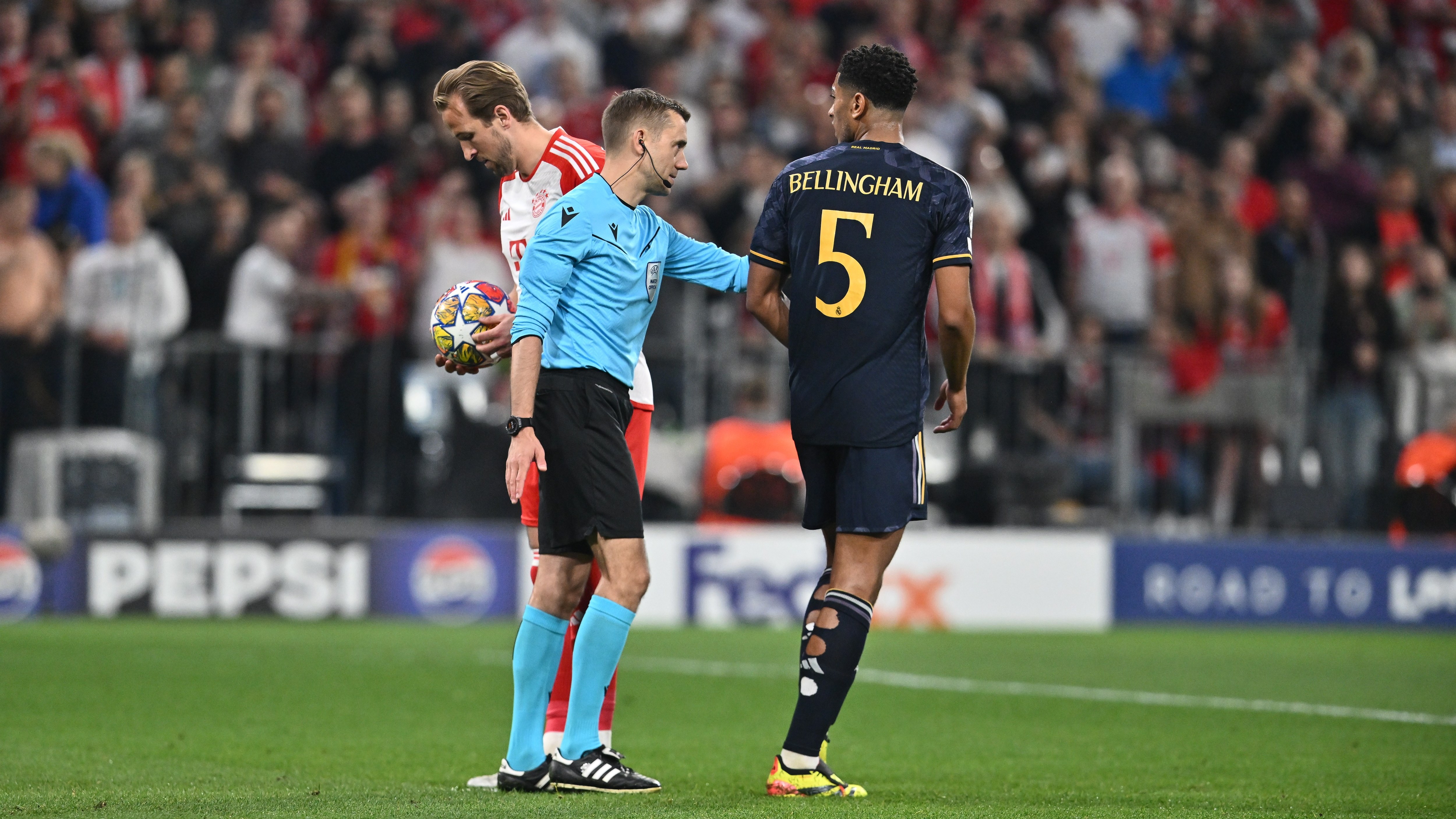 Bellingham is instructed to move away by the referee as Kane shrugs off the distraction in the first leg of the Champions League semi-final