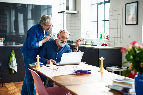 Older couple looking at laptop in their kitchen